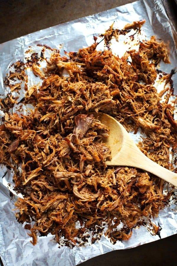 Pork on tin foil with a wooden spoon.