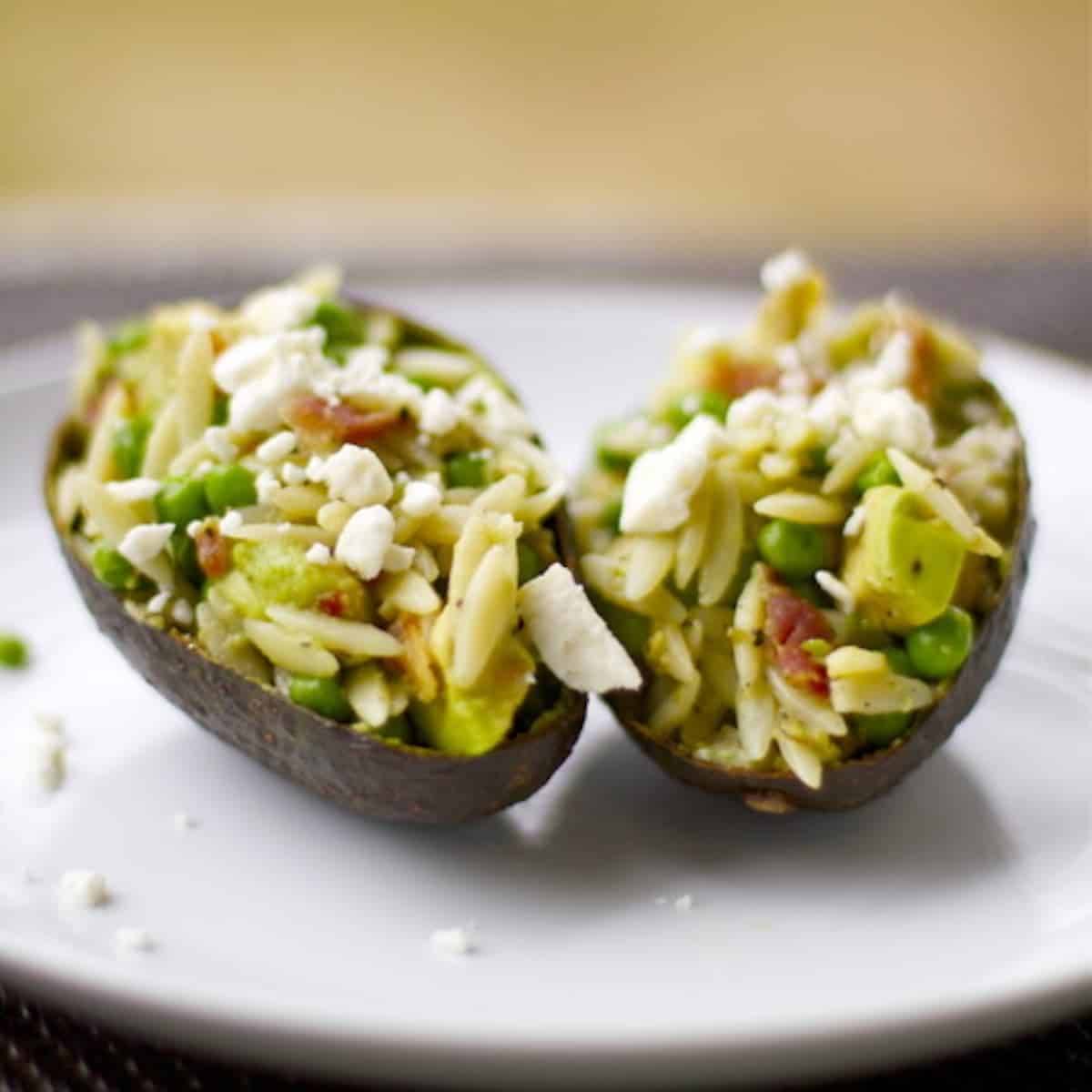 Avocado Bacon Orzo with feta cheese served in an avocado peel.