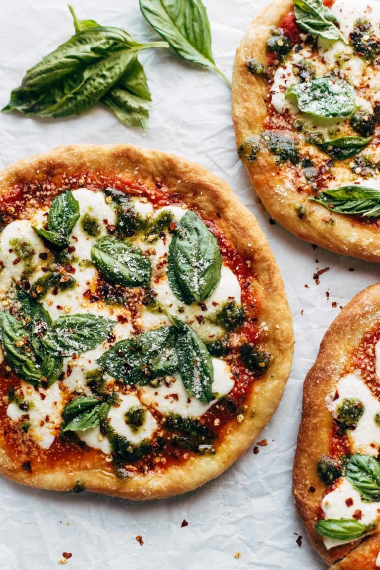 Fried Pizzas on parchment paper with basil.