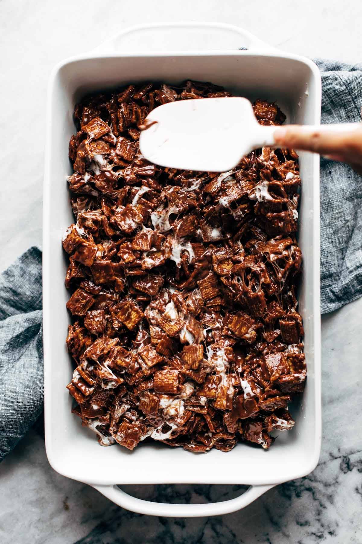 Spreading Golden Grahams Bars into pan.