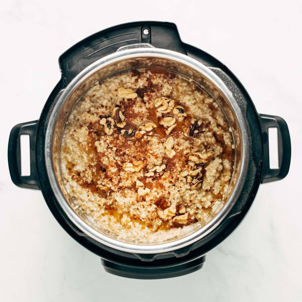Cooked oatmeal in the Instant Pot with nuts and brown sugar on top.
