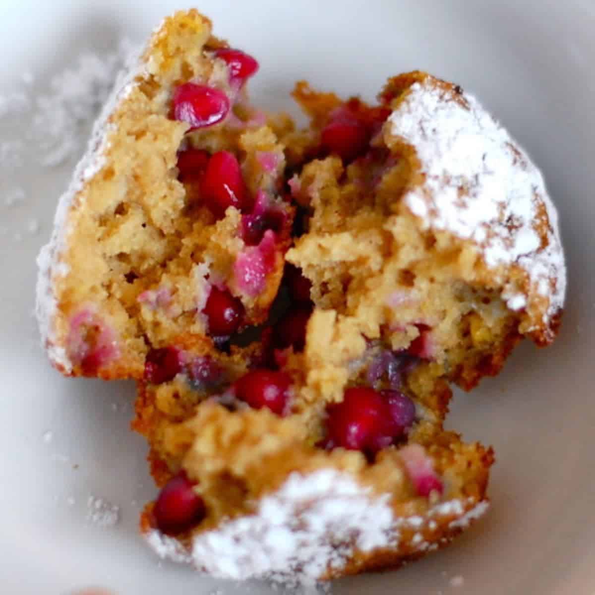Insdie of a pomegranate orange muffin with powdered sugar topping.