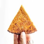 Sweet Potato Pizza Crust slice held by hand.