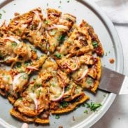 Sweet Potato Pizza on pizza pan with spatula.