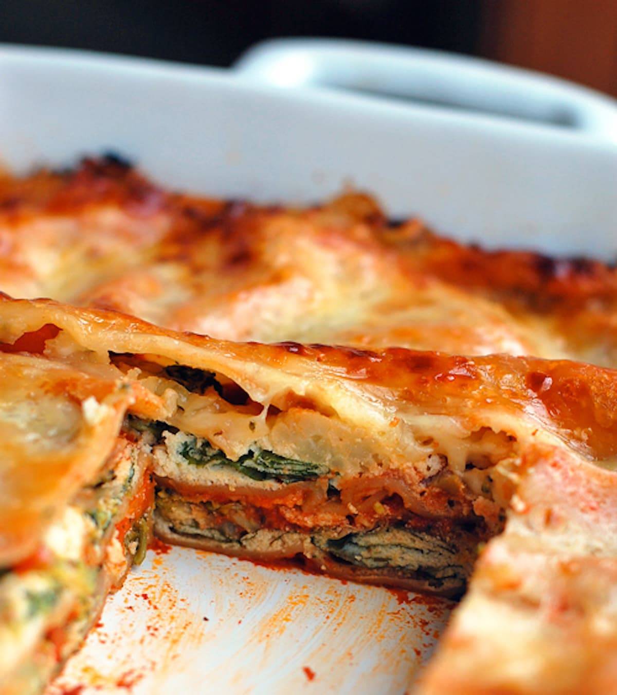 Veggie lasagna full of chopped broccoli, carrots, cauliflower, spinach, ricotta cheese, and tomato sauce.